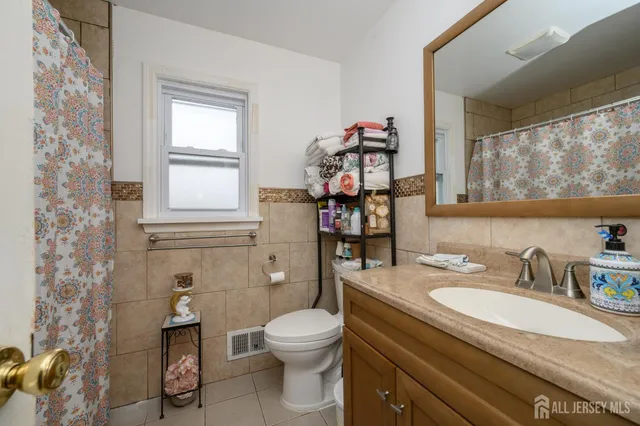a bathroom with a granite countertop toilet sink and mirror