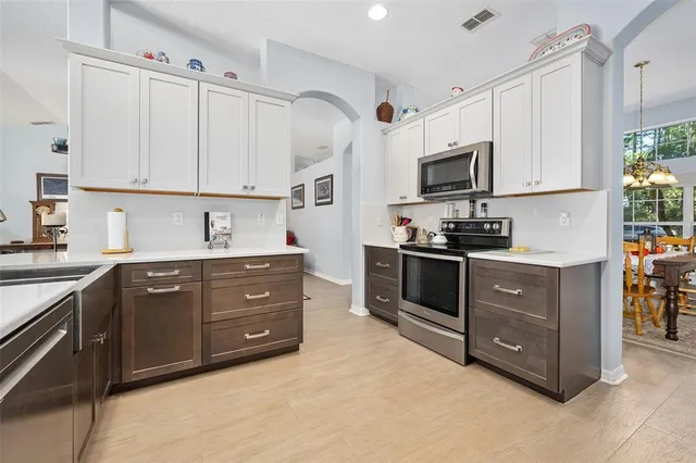 a kitchen with stainless steel appliances a stove a microwave and sink