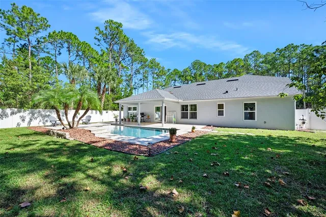 an aerial view of a house with a garden and trees all around