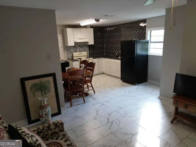 a kitchen with stainless steel appliances kitchen island granite countertop a refrigerator and a stove top oven