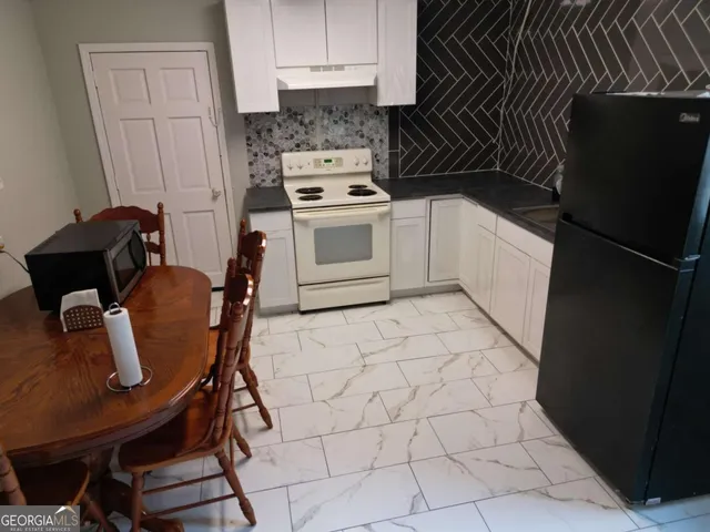 a kitchen with a stove a refrigerator and cabinets