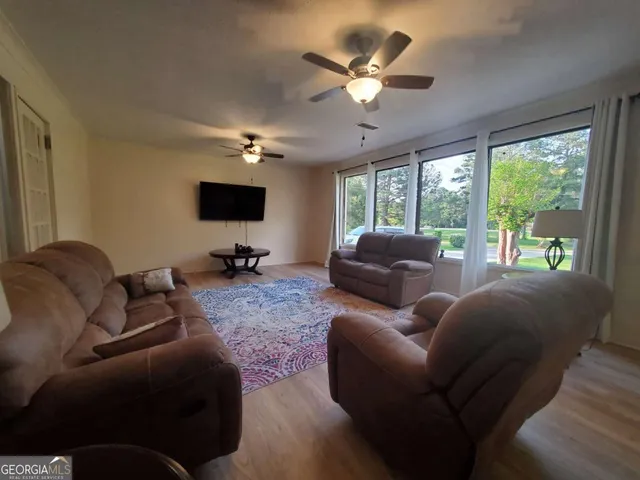 a living room with furniture a large window and a flat screen tv