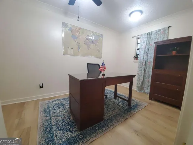 a workspace room with wooden floor and furniture