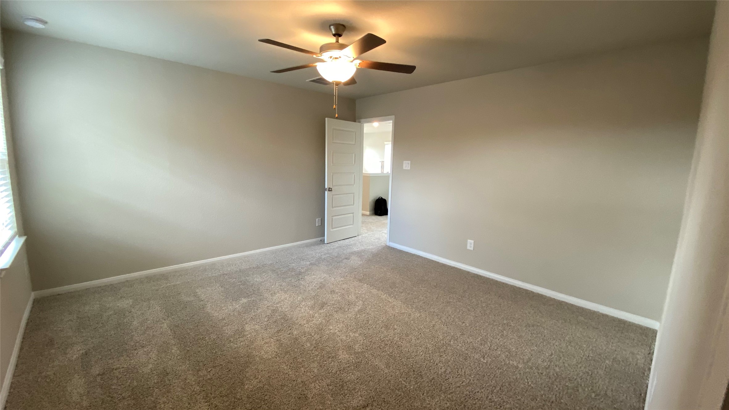 7059 Silverleaf Oak Street Conroe, TX 77304 - Photo 24 of 29 an empty room with a chandelier fan and windows