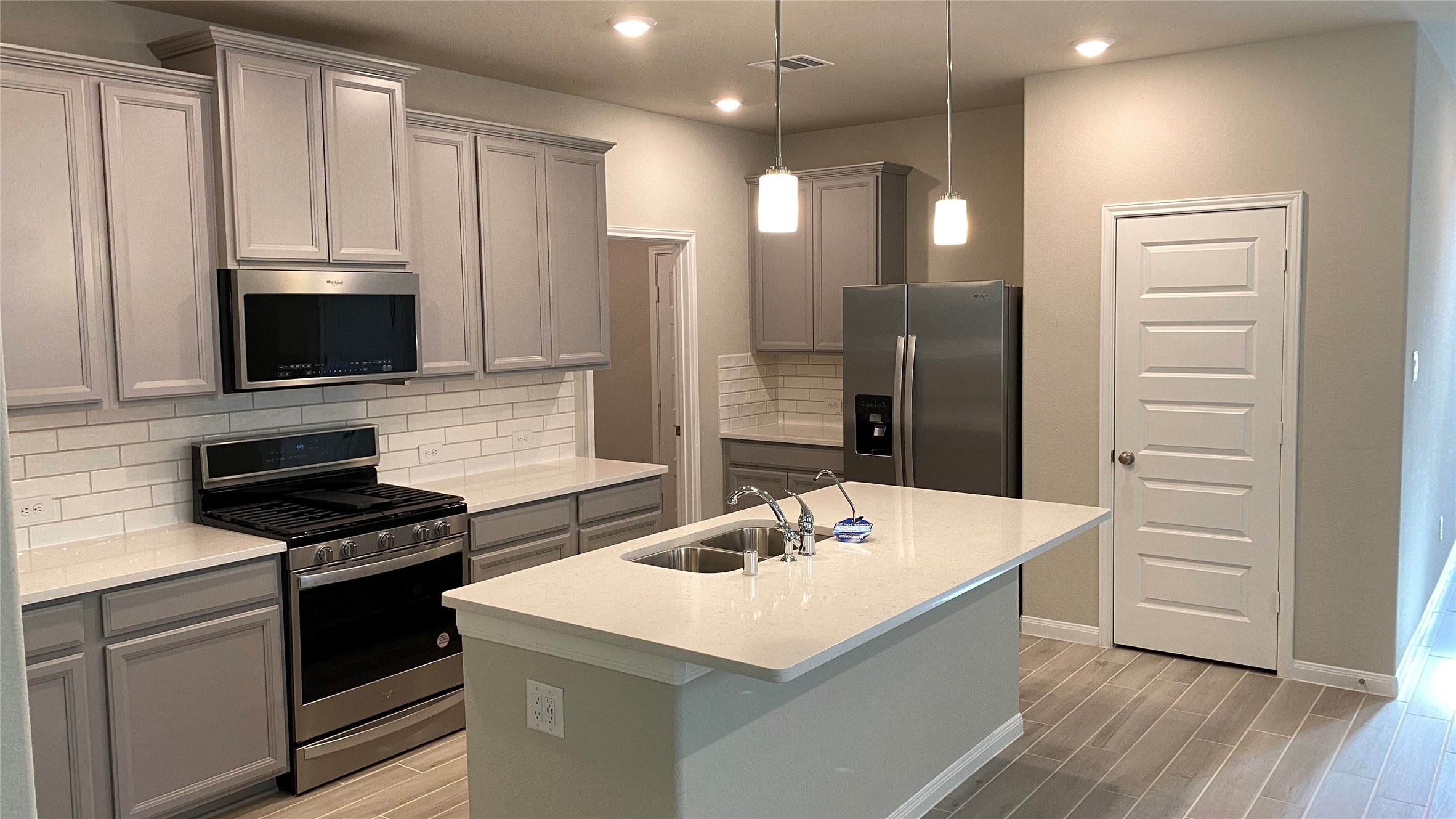 7059 Silverleaf Oak Street Conroe, TX 77304 - Photo 10 of 29 a kitchen with a sink a stove and refrigerator