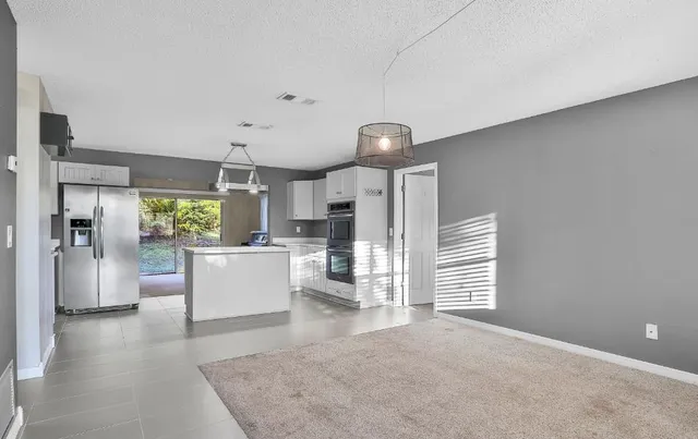 a view of a living room and kitchen with furniture and a ceiling fan