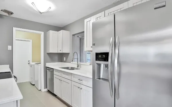 a kitchen with a refrigerator a sink and cabinets