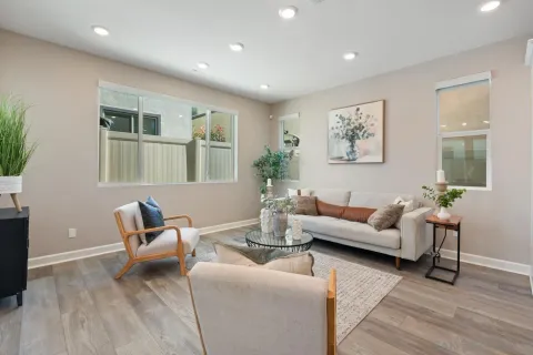 a dining room with furniture a large window and wooden floor
