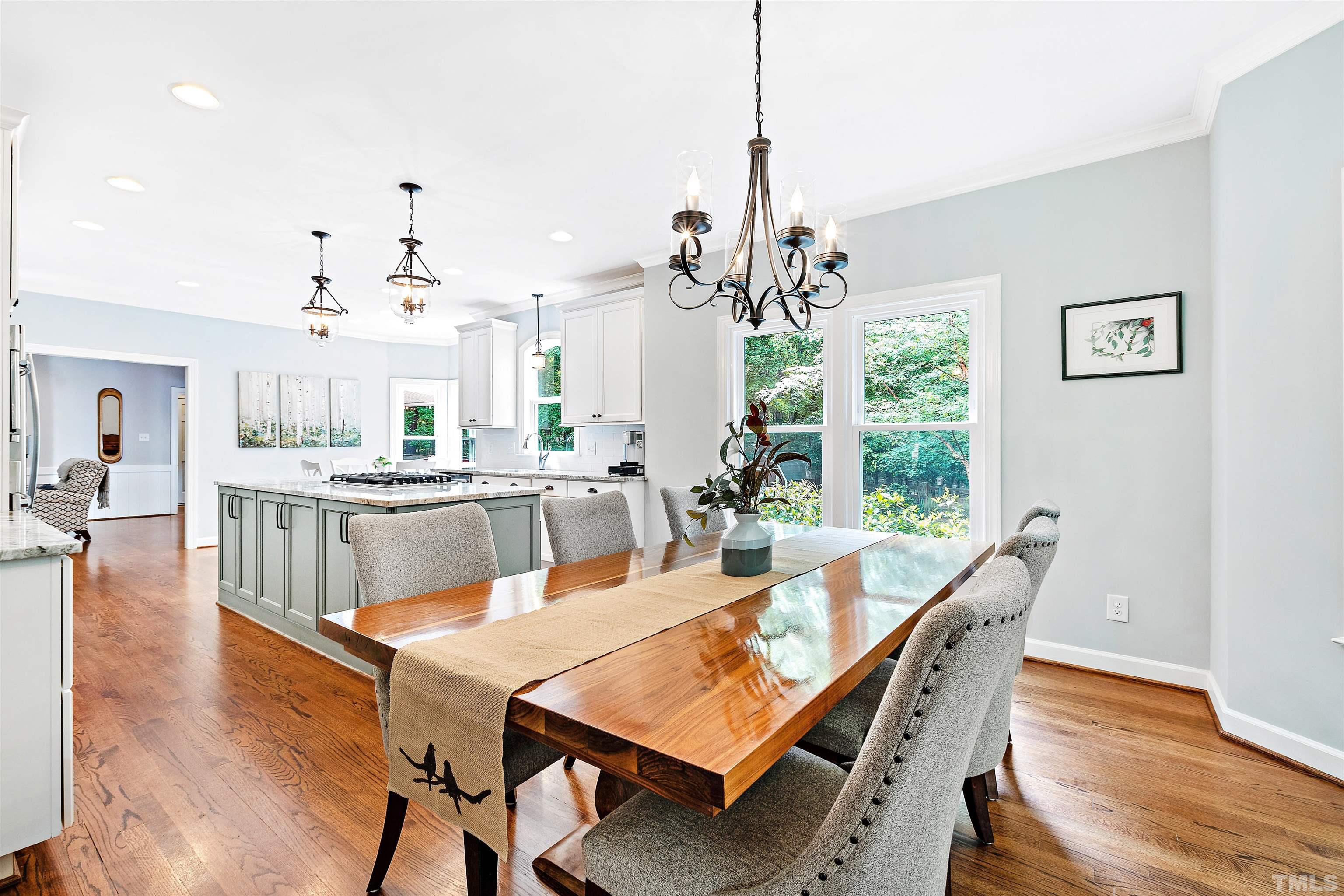4708 Fallswood Place Raleigh, NC 27613 - Photo 12 of 45 a view of a dining room and livingroom with furniture wooden floor a chandelier