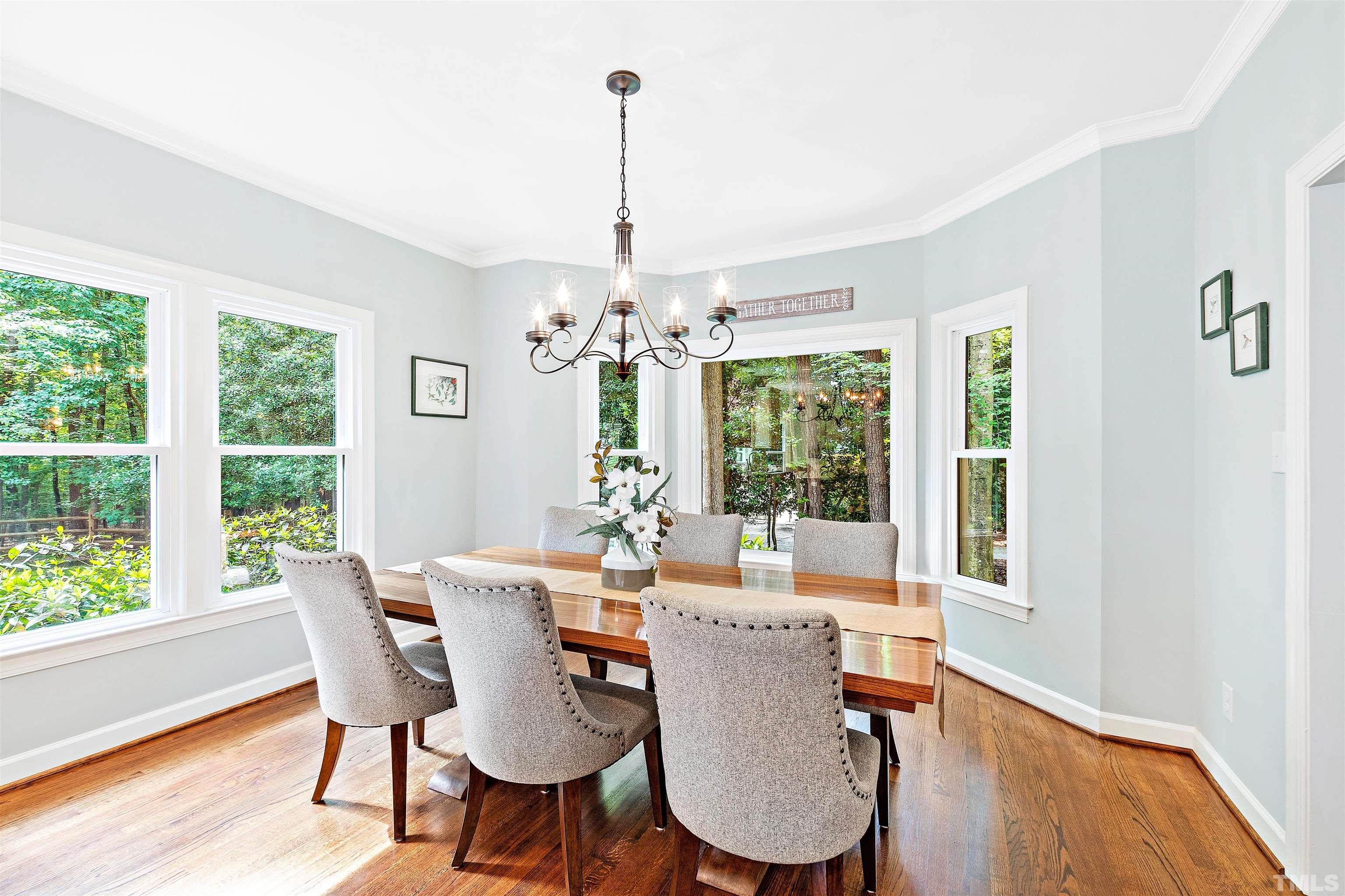 4708 Fallswood Place Raleigh, NC 27613 - Photo 13 of 45 a view of a dining room with furniture a chandelier and wooden floor