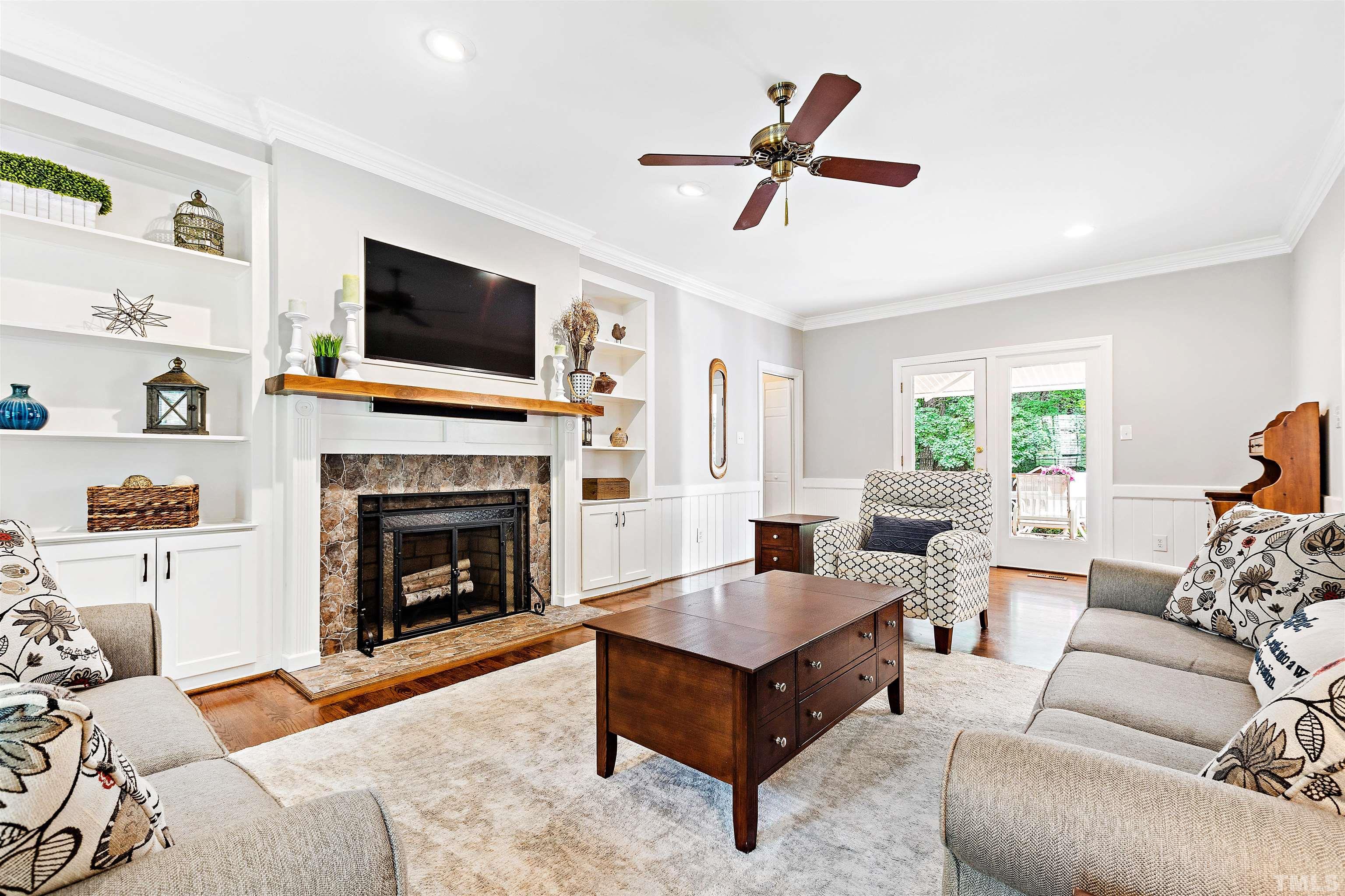4708 Fallswood Place Raleigh, NC 27613 - Photo 14 of 45 a living room with furniture a flat screen tv and a fireplace