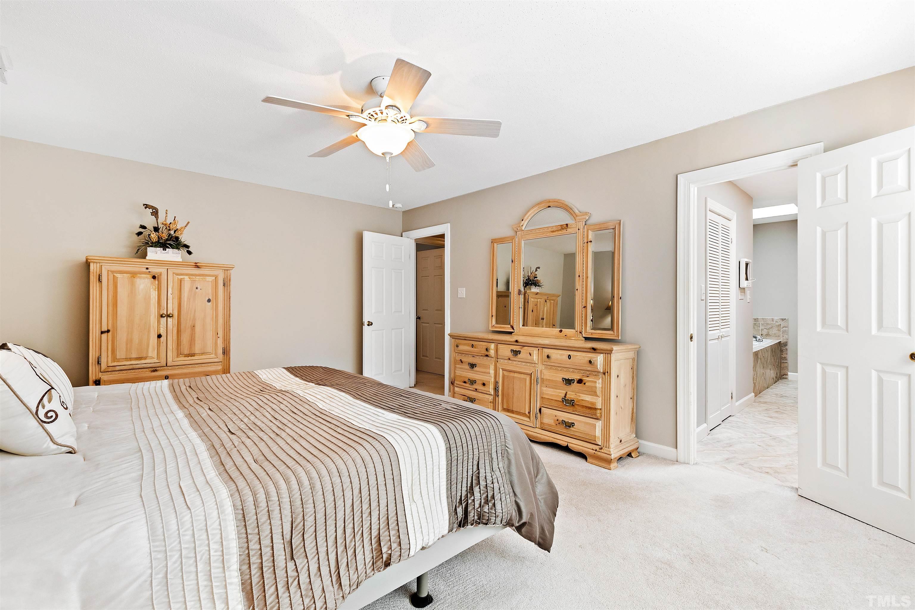 4708 Fallswood Place Raleigh, NC 27613 - Photo 23 of 45 a bedroom with a bed and a chandelier