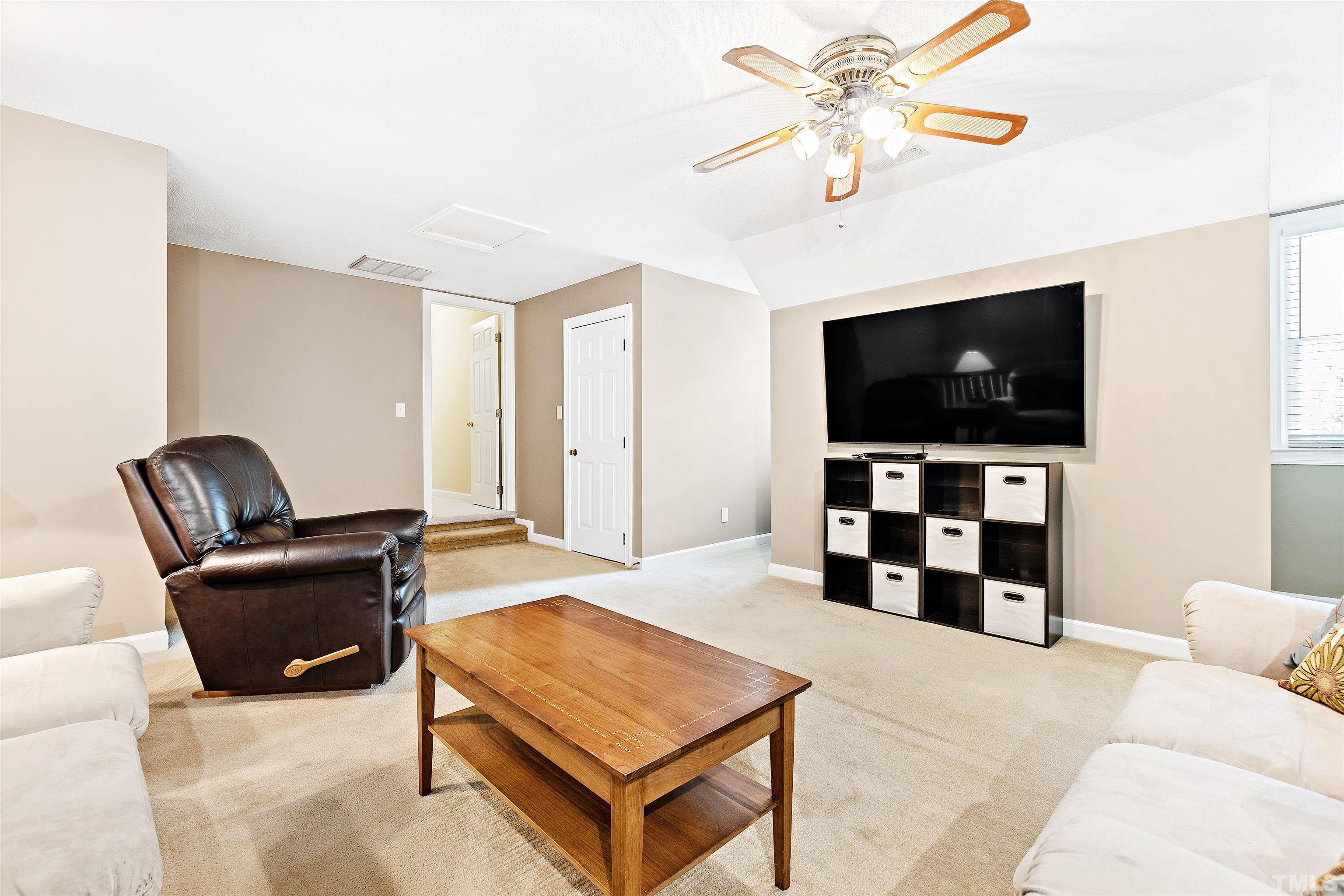 4708 Fallswood Place Raleigh, NC 27613 - Photo 36 of 45 a living room with furniture and a flat screen tv