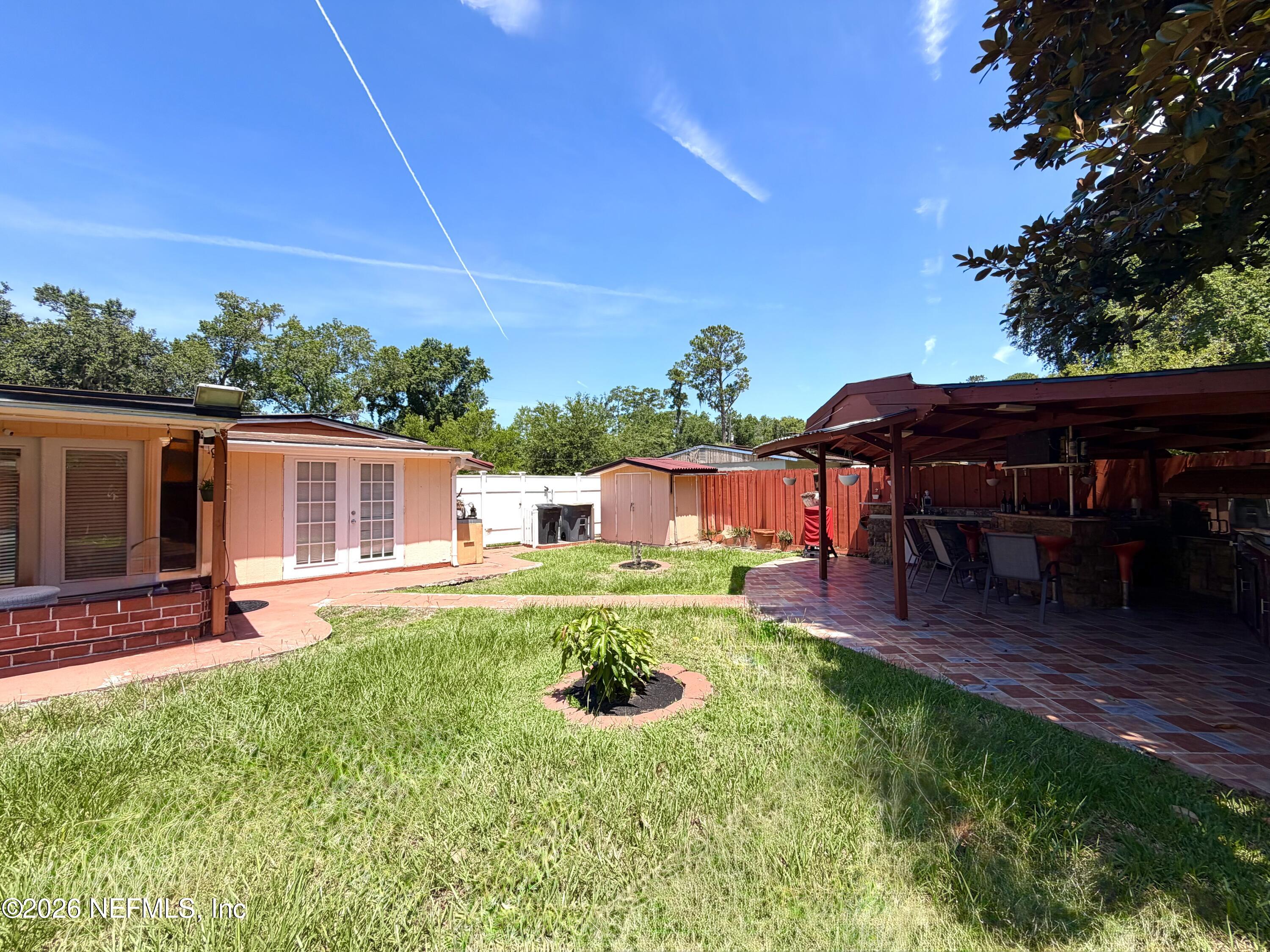 4127 Springwood Road Jacksonville, FL 32207 - Photo 40 of 63 a view of a backyard with table and chairs under an umbrella