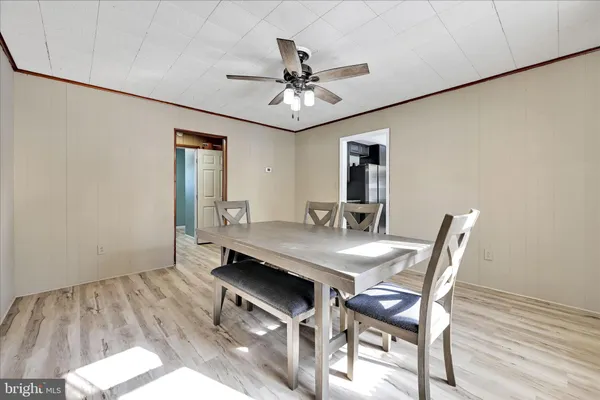 a view of a dining room with furniture and a chandelier fan