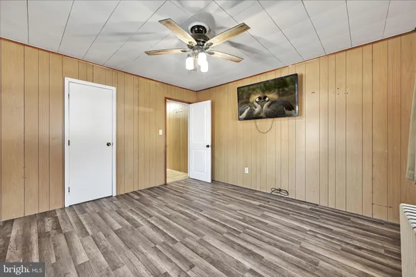 a view of a livingroom with a ceiling fan & hardwood floor