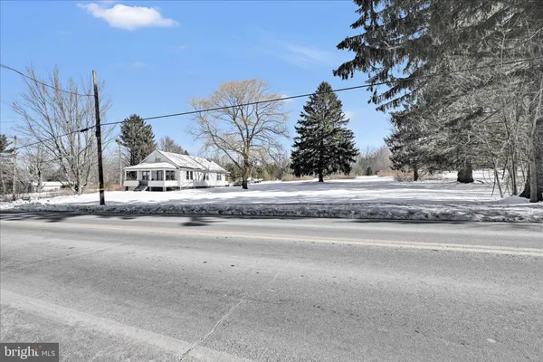 a front view of a house with a yard covered in snow