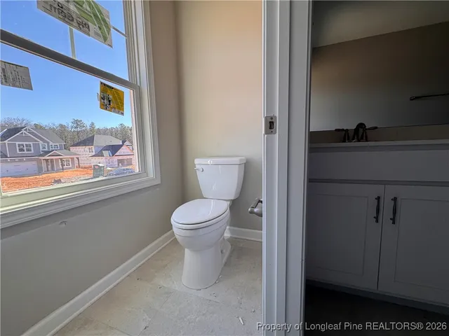 a bathroom with a toilet and a painting on the wall