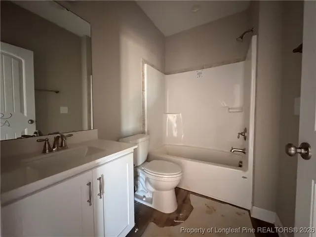 a bathroom with a sink toilet vanity and shower