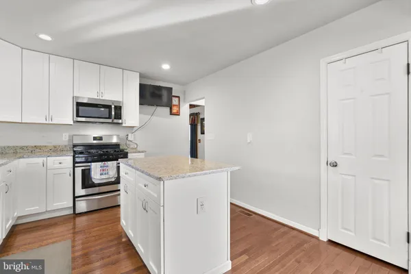 a kitchen with a stove top oven and refrigerator
