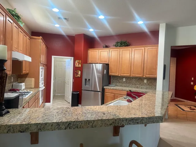 a kitchen with stainless steel appliances granite countertop a sink refrigerator and microwave