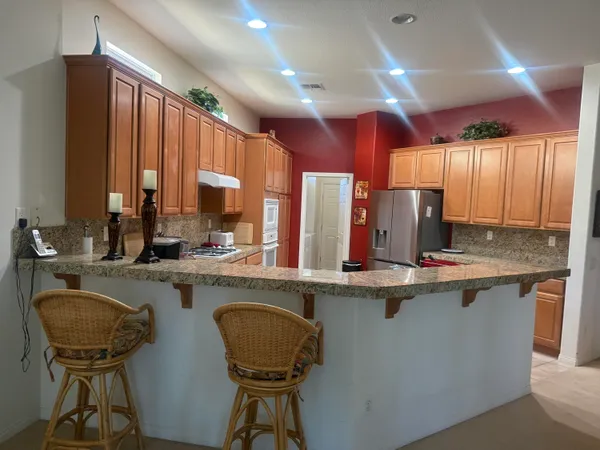 a kitchen with a table chairs sink and cabinets