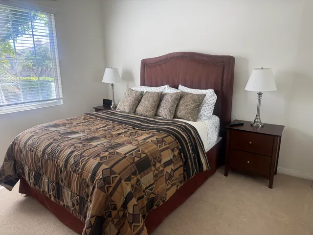 a bed sitting in a bedroom next to a window