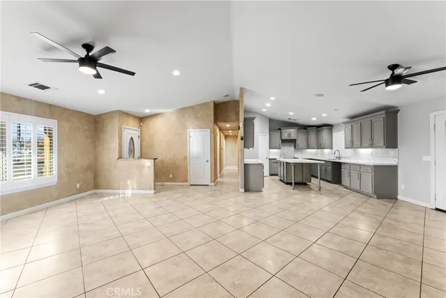 a large kitchen with a large counter top a sink stainless steel appliances and cabinets
