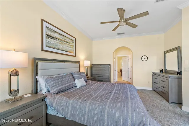 a bedroom with a large bed and a chandelier