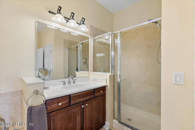 a bathroom with a sink mirror and a shower