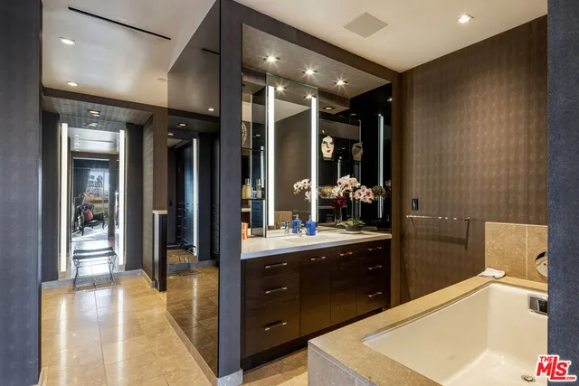 a bathroom with a tub sink and mirror