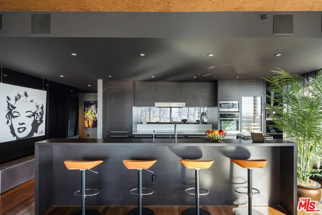 a kitchen with lots of white furniture and chairs
