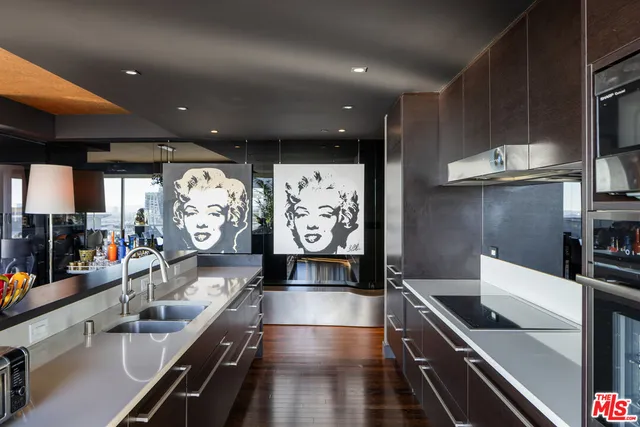 a kitchen with stainless steel appliances kitchen island granite countertop a stove and a sink