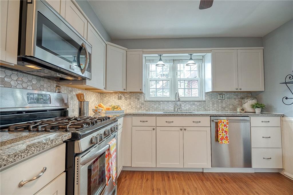 732 Charles Street Rochester, PA 15074 - Photo 23 of 38 a kitchen with stainless steel appliances granite countertop a stove a sink and a microwave