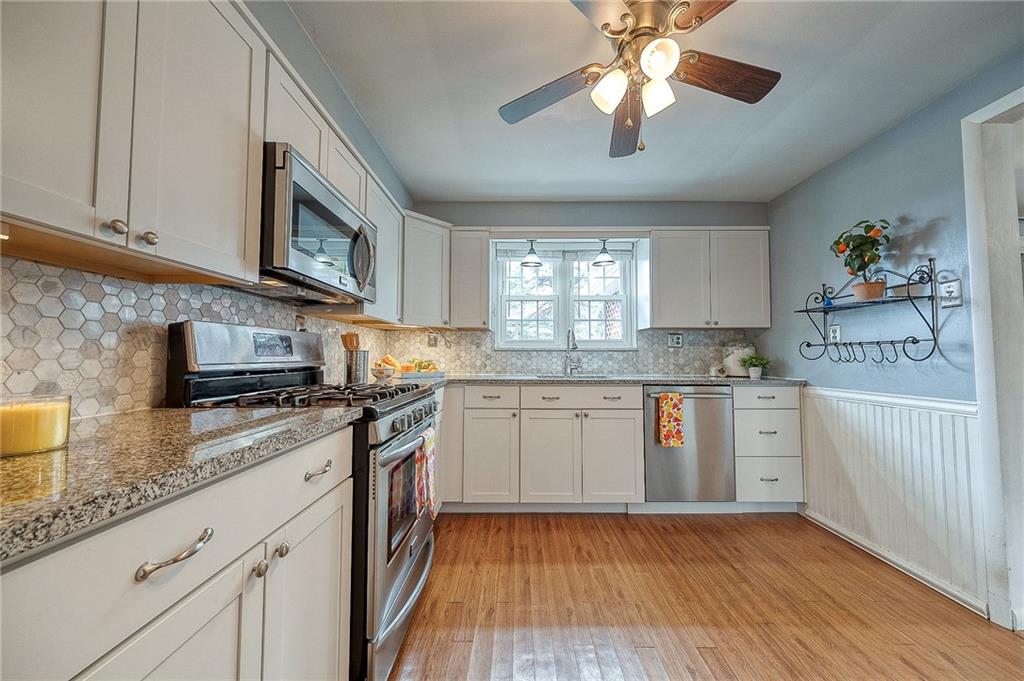 732 Charles Street Rochester, PA 15074 - Photo 24 of 38 a kitchen with stainless steel appliances granite countertop a sink a stove cabinets and wooden floor