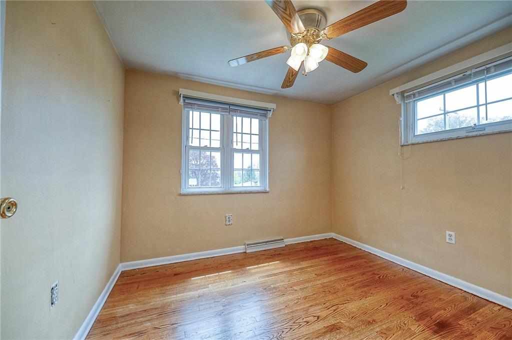 732 Charles Street Rochester, PA 15074 - Photo 30 of 38 an empty room with wooden floor chandelier fan and windows