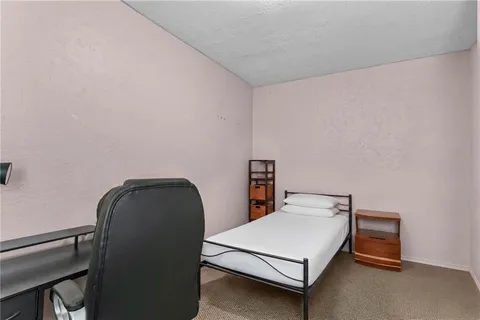 a bed sitting in a bedroom next to a window