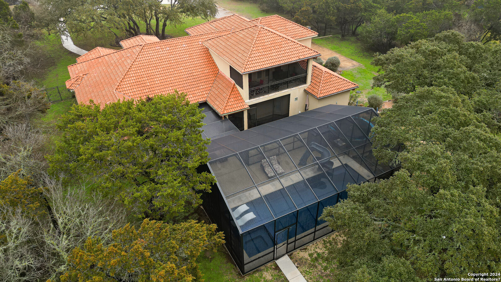 a aerial view of a house with a yard and large trees