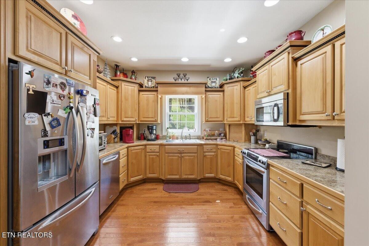 1999 Repass Road New Market, TN 37820 - Photo 13 of 52 a kitchen with stainless steel appliances granite countertop a refrigerator a sink dishwasher a stove and white cabinets with wooden floor