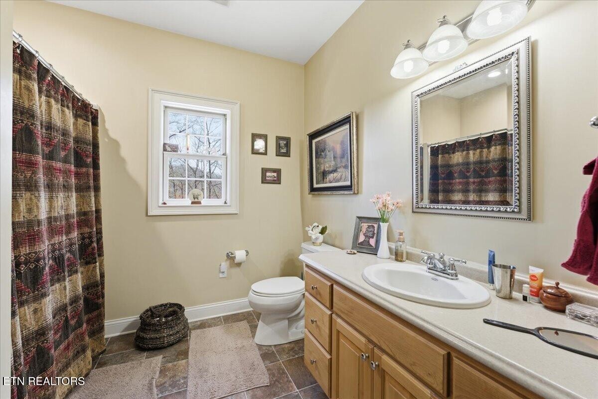 1999 Repass Road New Market, TN 37820 - Photo 26 of 52 a bathroom with a granite countertop toilet sink and mirror