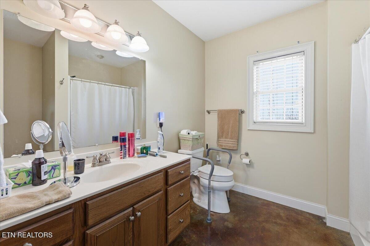 1999 Repass Road New Market, TN 37820 - Photo 33 of 52 a bathroom with a granite countertop sink a toilet and a mirror