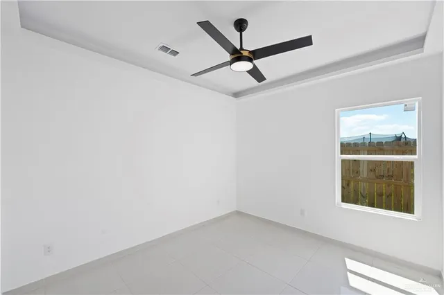 an empty room with a window and a fan