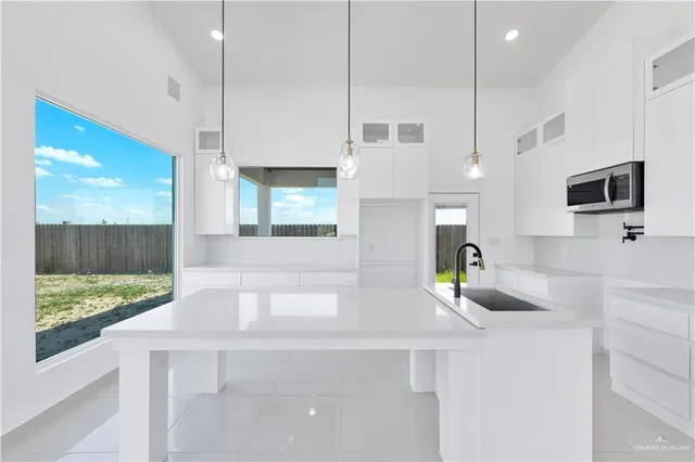 a kitchen with stainless steel appliances granite countertop a sink a stove and a wooden floors