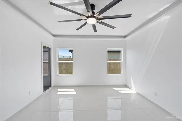 an empty room with windows and fan
