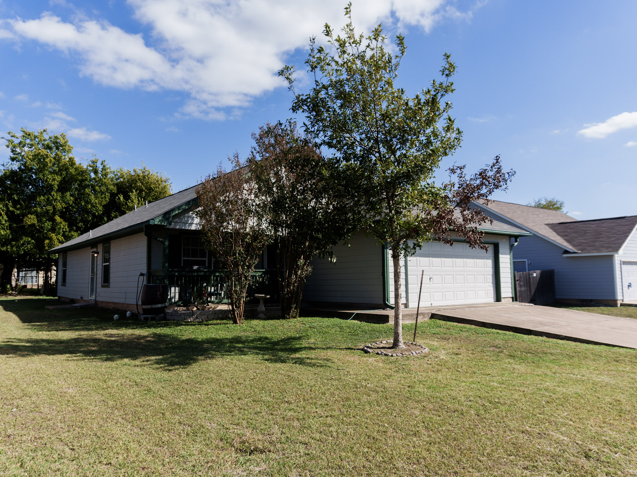 800 Debra Drive Taylor, TX 76574 - Photo 1 of 17 View of front of home with driveway, a front yard, a garage, and a wooden deck