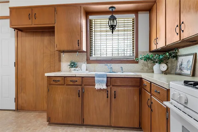 a kitchen with stainless steel appliances a sink cabinets and a window