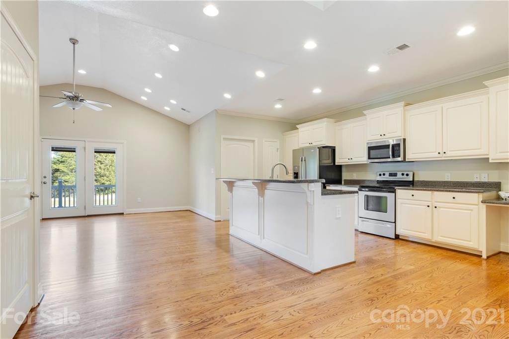 295 Brians Way Rutherfordton, NC 28139 - Photo 5 of 38 a large kitchen with stainless steel appliances granite countertop a stove a sink a refrigerator and white cabinets with wooden floor