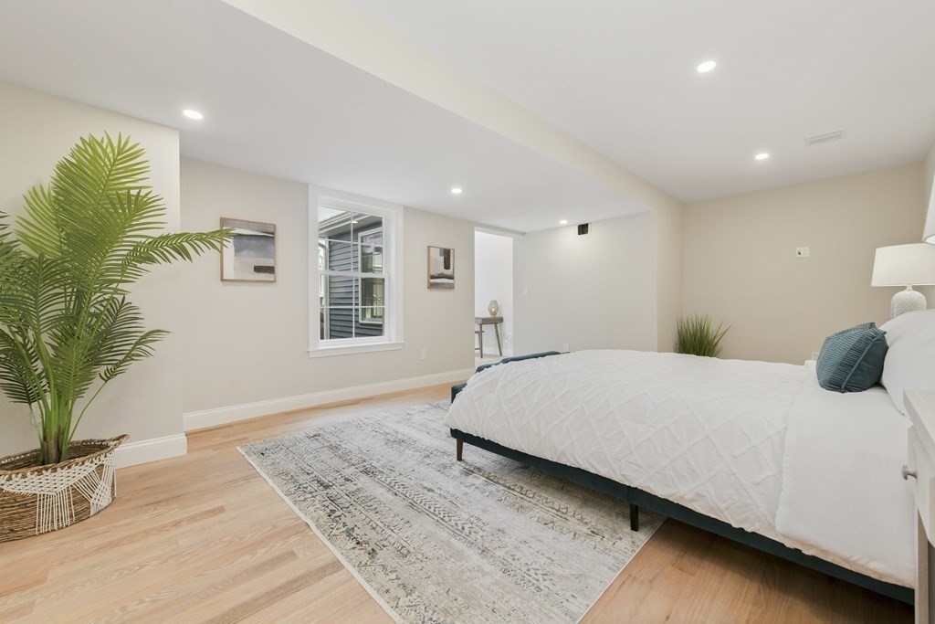 25 Locust Street, Unit 1 Winthrop, MA 02152 - Photo 13 of 38 a bedroom with a large bed and a potted plant