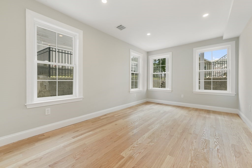 25 Locust Street, Unit 1 Winthrop, MA 02152 - Photo 18 of 38 an empty room with wooden floor and windows
