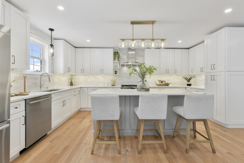 25 Locust Street, Unit 1 Winthrop, MA 02152 - Photo 10 of 38 a kitchen with a dining table chairs stainless steel appliances and cabinets